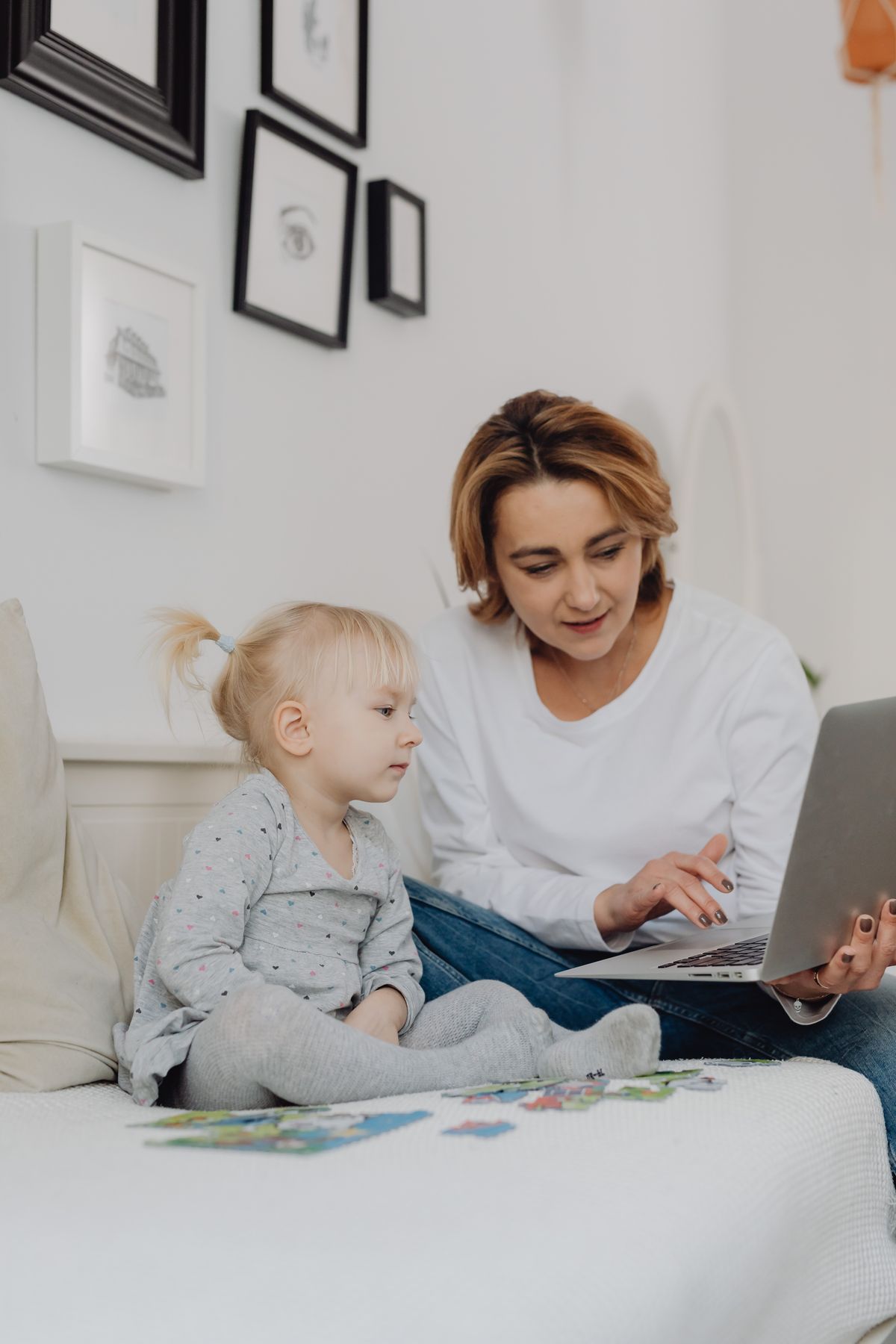 Mama pokazująca córce laptopa w domu