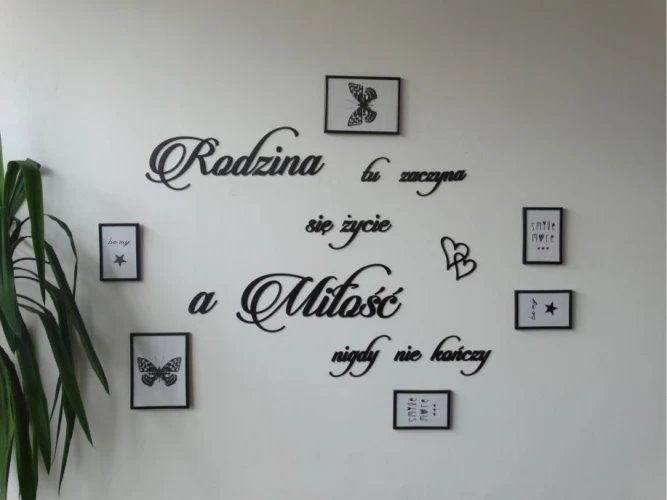 Dekoracja ścienna z białymi napisami w stylu script zawierającymi słowa 'Rodzina', 'Miłość' i małymi grafikami w ramkach